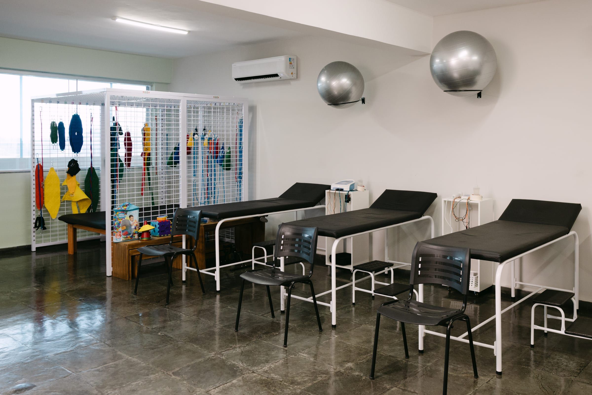 Salão de atendimento amplo com macas e climatização